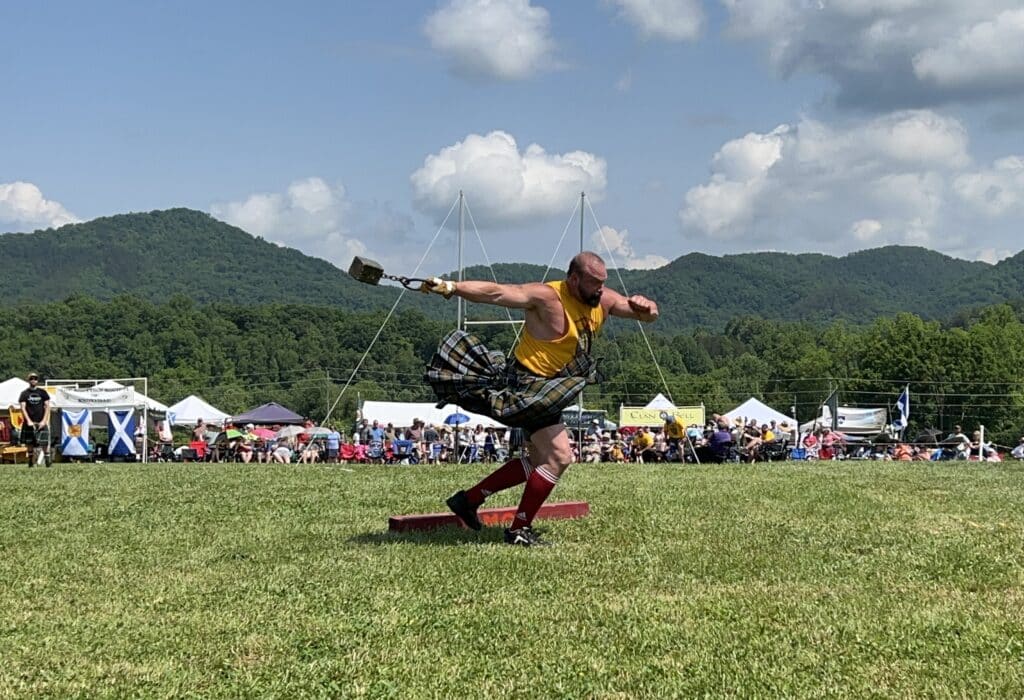 A man throws a heavy weight at the Highland games.
